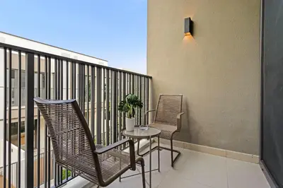 a balcony with two chairs and a table on a balcony at Silkhaus Spacious 3BDR & Maid Tilal Al Ghaf in Dubai