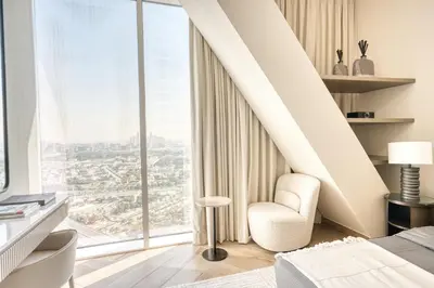 a bedroom with a large window and a chair at Upscale Modern 2-Bedroom with Elegant Interiors in Dubai