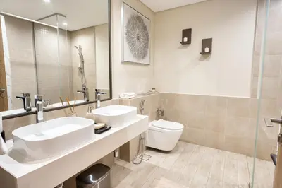 a bathroom with two sinks and a toilet at Upscale Modern 2-Bedroom with Elegant Interiors in Dubai
