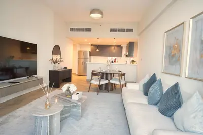a living room with a white couch and a table at Upscale Modern 2-Bedroom with Elegant Interiors in Dubai
