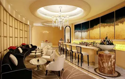 a hotel lobby with a bar and tables and chairs at Al Habtoor Palace - Preferred Hotels & Resorts in Dubai