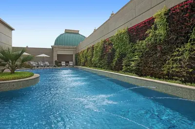 a swimming pool in front of a building at Al Habtoor Palace - Preferred Hotels & Resorts in Dubai