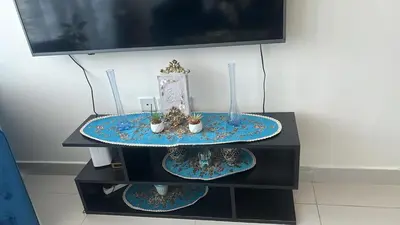 a table with two plates and a tv on it at شقة غرفة وصالة Apartment one bad room in Dubai