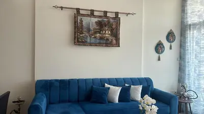 a blue couch in a living room with a picture on the wall at شقة غرفة وصالة Apartment one bad room in Dubai