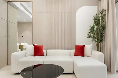 a living room with a white couch and red pillows at FIRST CLASS 1BR Pearl House Elegance in Dubai