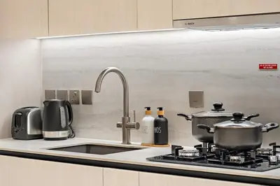 a kitchen with a sink and a stove with pots and pans at FIRST CLASS 1BR Pearl House Elegance in Dubai
