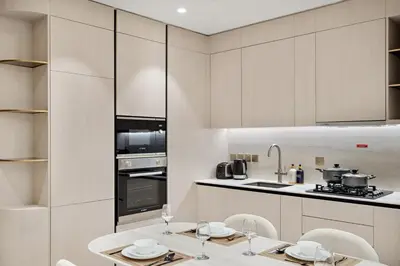 a kitchen with a table and chairs in a room at FIRST CLASS 1BR Pearl House Elegance in Dubai
