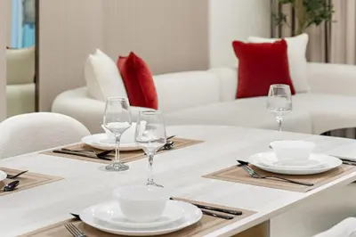 a dining table with glasses and plates on it at FIRST CLASS 1BR Pearl House Elegance in Dubai