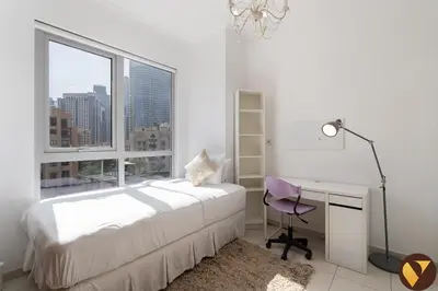 a bedroom with a bed and a desk and a window at Vogue Downtown Burj Residence Near Dubai Mall and Burj Khalifa, Three Bedroom Plus Maid's room Apartment with Balcony and City View, Access to all Amenities in Dubai
