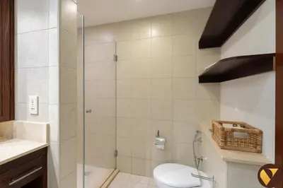a bathroom with a toilet and a glass shower at Vogue Downtown Burj Residence Near Dubai Mall and Burj Khalifa, Three Bedroom Plus Maid's room Apartment with Balcony and City View, Access to all Amenities in Dubai