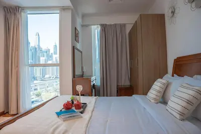 a bedroom with a large bed with a large window at Stylish 1BR close to Metro and Dubai Marina in Dubai