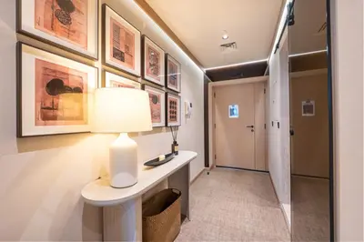 a hallway with a table with a lamp and some pictures at Modern and Stylish 2-BR High Floor All Bills Included in Dubai