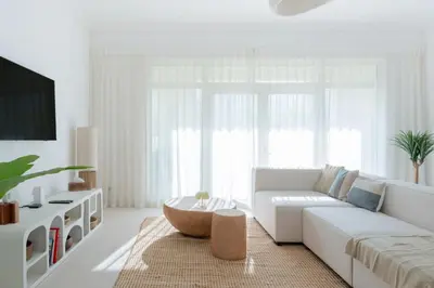a white living room with a white couch and a table at Modern & Bright 2 Bedroom Apartment at The Palm in Dubai