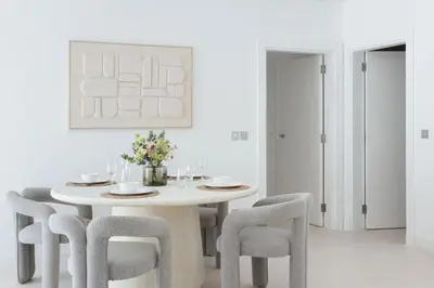 a white dining room with a white table and chairs at Modern & Bright 2 Bedroom Apartment at The Palm in Dubai