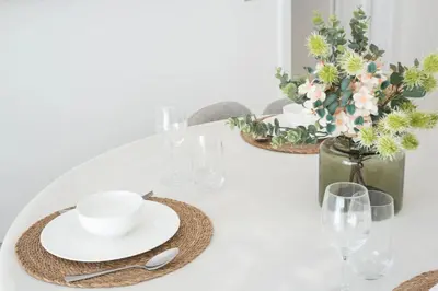 a white table with plates and glasses and flowers at Modern & Bright 2 Bedroom Apartment at The Palm in Dubai