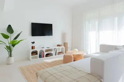 a white living room with a white couch and a tv at Modern & Bright 2 Bedroom Apartment at The Palm in Dubai