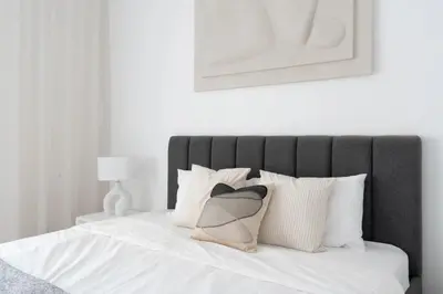 a bedroom with a bed with white sheets and pillows at Modern & Bright 2 Bedroom Apartment at The Palm in Dubai