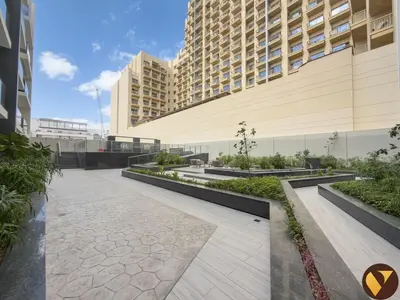 a walkway in front of a large building at Vogue JVC Al Serh Residences Near Circle Mall, One Bedroom Plus Maid's room Apartment with Balcony and City View, Access to all Amenities in Dubai