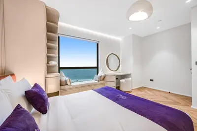 a bedroom with a large bed with a large window at Modern 1BR JBR Stunning Sea & Ain Dubai Views in Dubai
