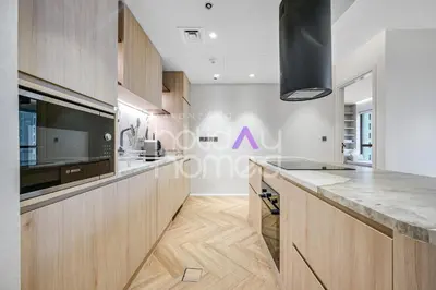 a kitchen with wooden cabinets and a counter top at Modern 1BR JBR Stunning Sea & Ain Dubai Views in Dubai