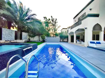 a swimming pool in front of a house at Royal Palazzo with private Pool and BBQ on Marina, huge 7Bedroom Villa in Dubai