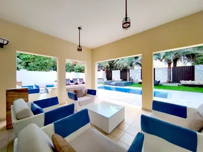 a living room with blue and white furniture and a pool at Royal Palazzo with private Pool and BBQ on Marina, huge 7Bedroom Villa in Dubai