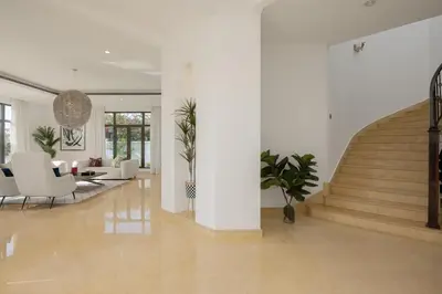 a living room with white furniture and a staircase at Maison Privee - Villa on Beach with Private Pool The Palm Jumeirah in Dubai