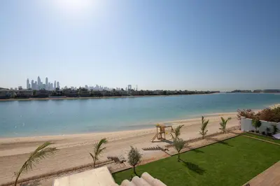 a view of a beach with a picnic table next to the water at Maison Privee - Villa on Beach with Private Pool The Palm Jumeirah in Dubai