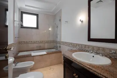 a bathroom with a sink and a tub and a toilet at Maison Privee - Villa on Beach with Private Pool The Palm Jumeirah in Dubai