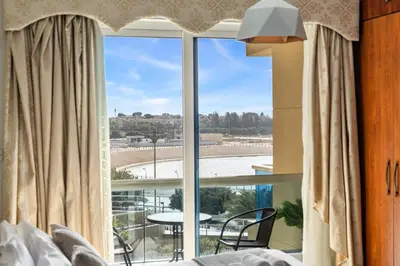 a bedroom with a large window with a view of a table at Sunny Studio with Pool, Gym & Sauna in Dubai Escape in Dubai