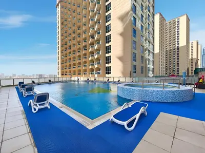 a pool on the roof of a building at Sunny Studio with Pool, Gym & Sauna in Dubai Escape in Dubai