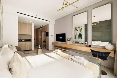 a living room with a bed and a tv at Chic and Peaceful Studio with Balcony & Pool in JVC in Dubai