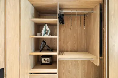 a walk in closet with wooden shelves at Chic and Peaceful Studio with Balcony & Pool in JVC in Dubai