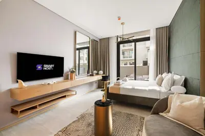 a hotel room with a bed and a tv at Chic and Peaceful Studio with Balcony & Pool in JVC in Dubai