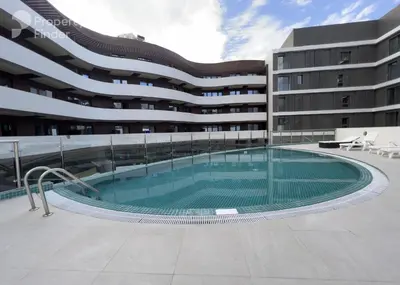 a swimming pool in front of a building at Modern One-Bedroom Apartment King and Queen Beds Two Bathrooms in Dubai