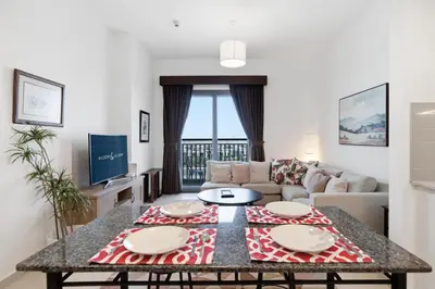 a living room with a table and a couch at Safi Apartments 2A, Town Square - 2 Bedroom Apartment - Allsopp & Allsopp in Dubai