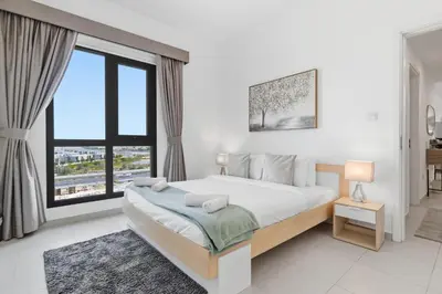 a bedroom with a large bed and a large window at Safi Apartments 2A, Town Square - 2 Bedroom Apartment - Allsopp & Allsopp in Dubai