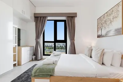 a bedroom with a large bed and a large window at Safi Apartments 2A, Town Square - 2 Bedroom Apartment - Allsopp & Allsopp in Dubai