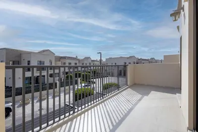 a balcony with a fence and some buildings at Jasmine Lane, JGE - 3 Bedroom with maids' room Townhouse - Allsopp & Allsopp in Dubai