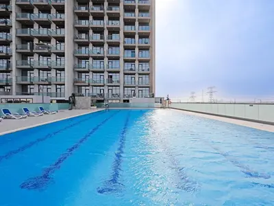 a large swimming pool in front of a building at Bright & Spacious 2-Bedroom Apartment Al furjan-706 in Dubai