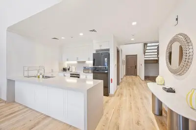 a kitchen with white cabinets and a large white counter top at Daniels 3BR Villa plus M at La Mer With Beach Access in Dubai