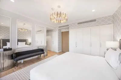 a bedroom with a white bed and a chandelier at Daniels 3BR Villa plus M at La Mer With Beach Access in Dubai