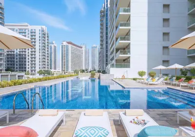 an image of a swimming pool at a hotel with buildings at Luxury Apt Canal View - 5min Burj & Dubai Mall in Dubai