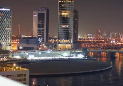 a view of a city at night with at Luxury Apt Canal View - 5min Burj & Dubai Mall in Dubai