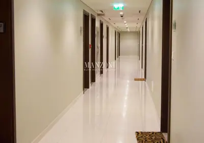 a corridor in a building with white floors and windows at Luxury Apt Canal View - 5min Burj & Dubai Mall in Dubai