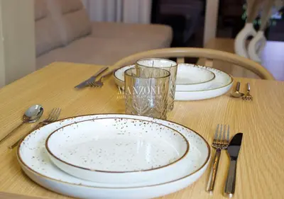 a table with two plates and a glass on it at Luxury Apt Canal View - 5min Burj & Dubai Mall in Dubai