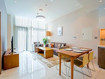 a living room with a table and a couch at Elegant 1-Bedroom Apartment in Al Furjan-G01 in Dubai