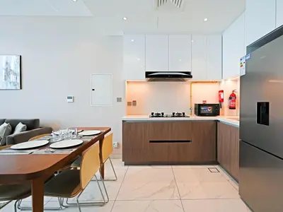 a kitchen and dining room with a table and a refrigerator at Elegant 1-Bedroom Apartment in Al Furjan-G01 in Dubai