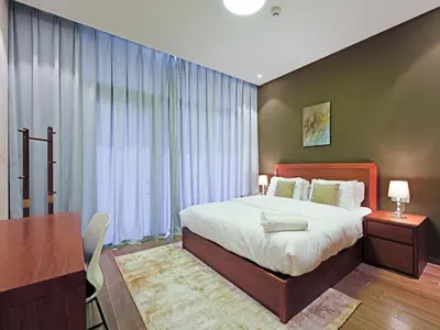 a bedroom with a large bed and a table and a desk at Spacious 2-Bedroom Apartment Al Furjan-104 in Dubai