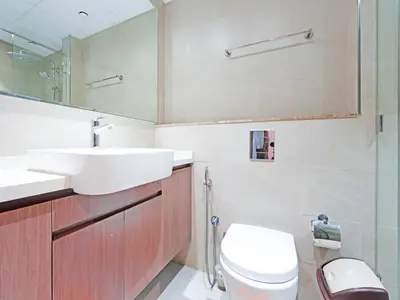 a bathroom with a sink and a toilet and a mirror at Spacious 2-Bedroom Apartment Al Furjan-104 in Dubai